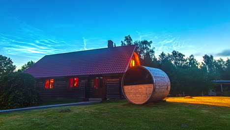 people living inside wooden cottage with barrel sauna during holiday trip - blue sky with flying clouds - vibrant constrast colors of time lapse footage