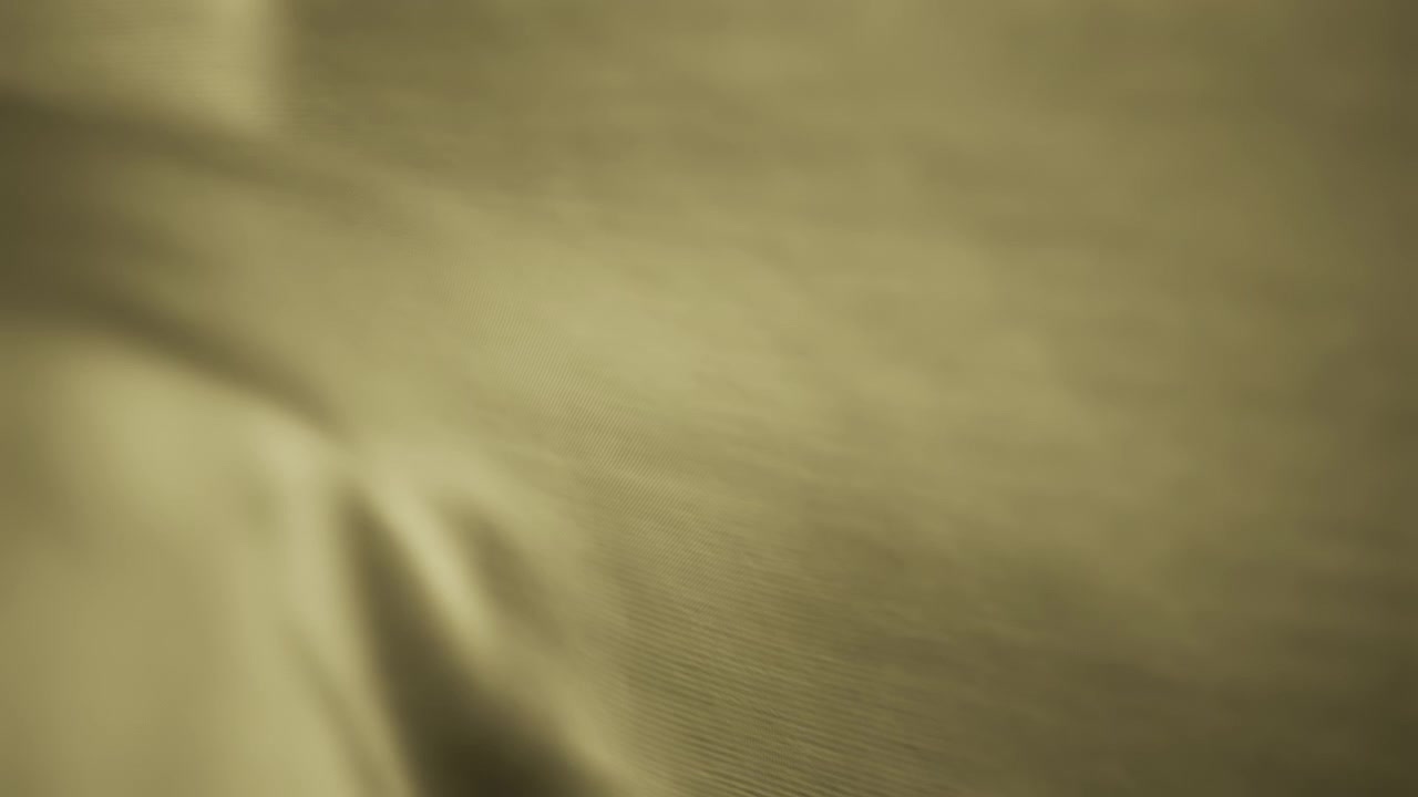 Texture background of yellow chiffon fabric waving in the wind