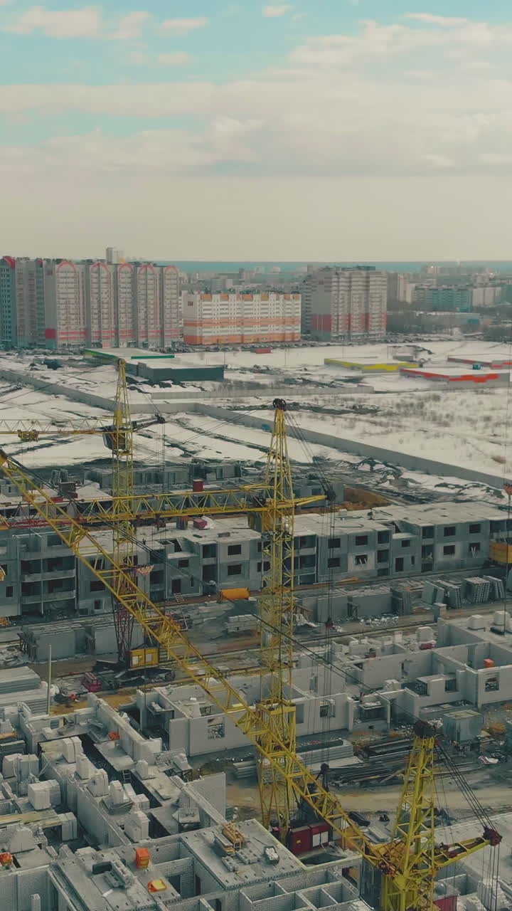 dwelling district construction site near wasteland covered with snow against residential panel houses and beautiful sky