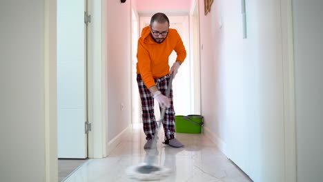 a young man helps his wife while cleaning his house.