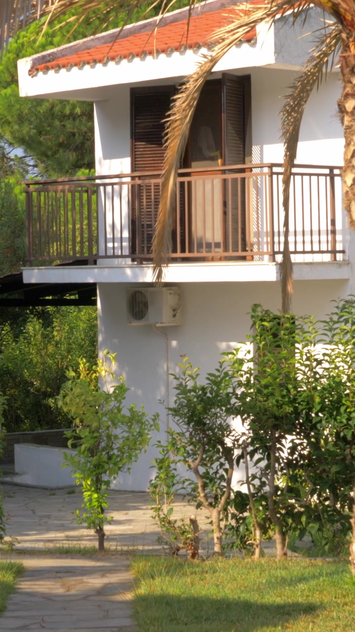 Cottage con palma nel giardino, scena estiva.