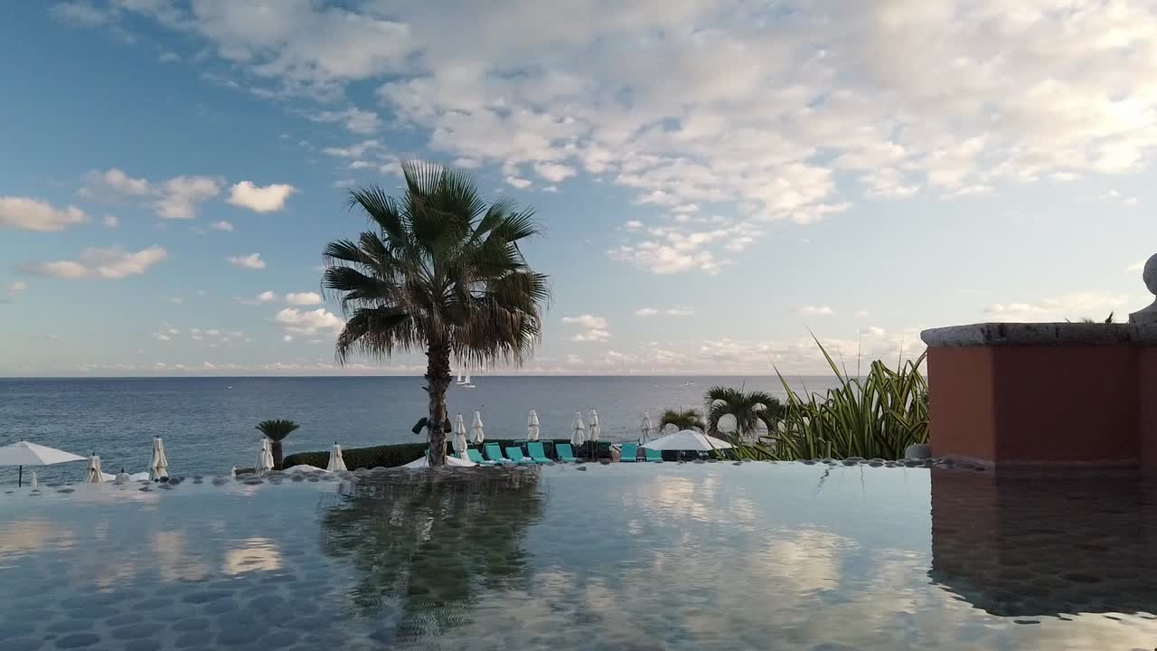 vista idílica sobre el horizonte del océano y barcos desde la piscina infinita del hotel de lujo con reflejo de espejo en la superficie del agua
