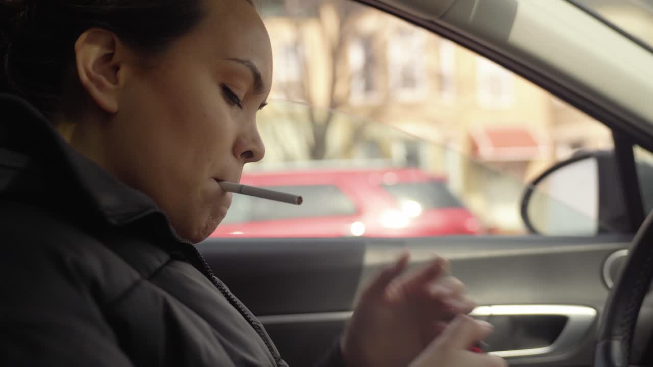 Woman lighting up a cigarette in a car