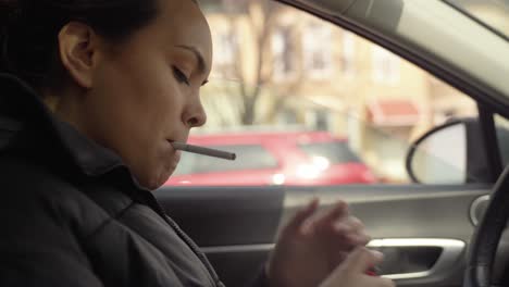 woman lighting up a cigarette in a car