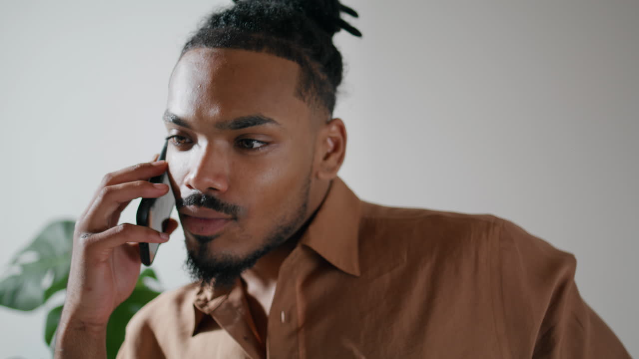 Confident businessman answering call home closeup. Dreadlocks guy talking mobile