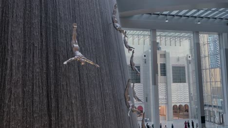 static night shot of dubai mall’s indoor waterfall with diving men sculptures and falling water in an elegant modern interior
