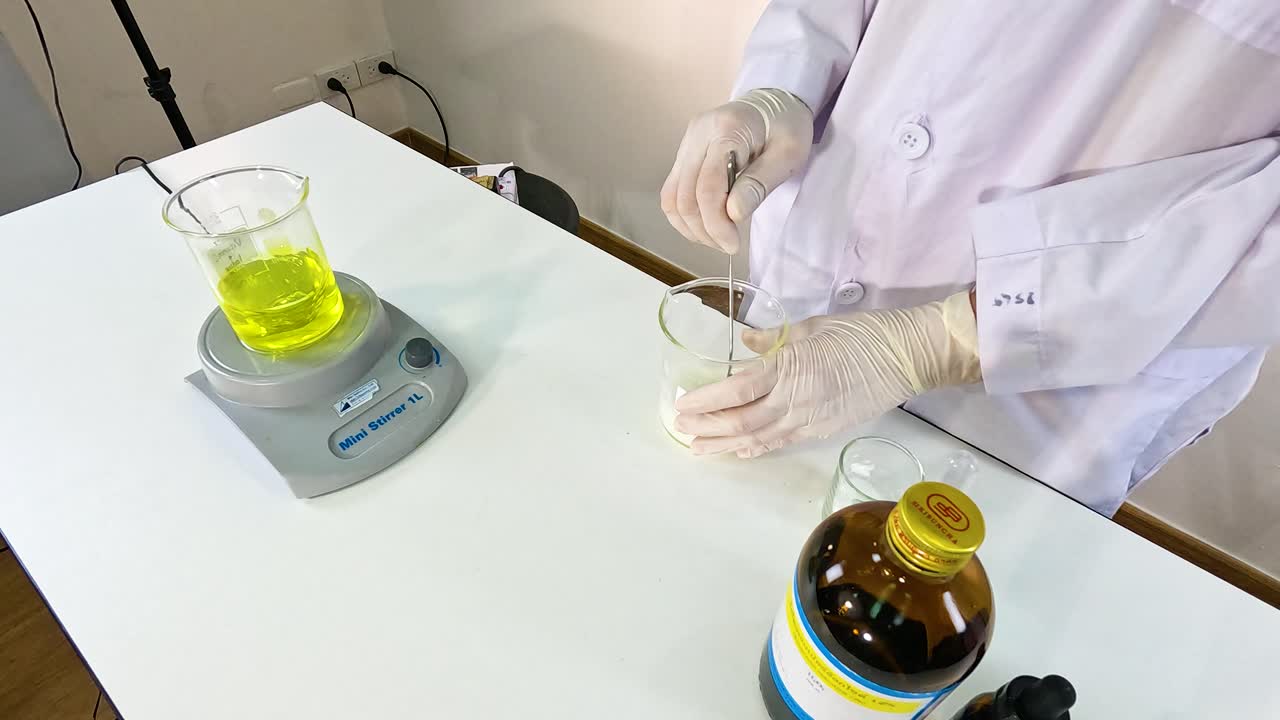 A scientist conducts an iodine clock reaction experiment, showcasing chemical changes in a controlled lab environment with precise measurements