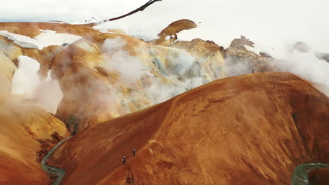 Hikers-Walking-Up-On-The-Ridge-In-Hveradalir-Geothermal-Area,-Kerlingarfjoll,-Iceland---high-angle-shot