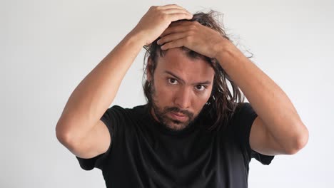 latino-man-checking-his-hair-with-receding-hairline-and-baldness,-DHT-blocker