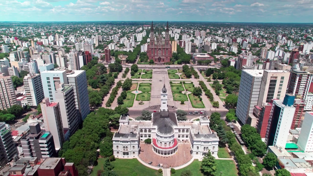 Ripresa aerea con drone in allontanamento dalle guglie della Cattedrale di La Plata, che rivela la piazza geometrica di Plaza Moreno, la torre del Municipio e la pianificazione urbana a griglia di Buenos Aires, Argentina