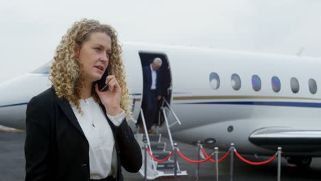 Businesswoman-talking-on-mobile-phone-at-terminal-4k