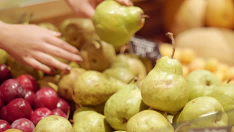 Woman-hands-laying-out-pears-in-a-grocery-store
