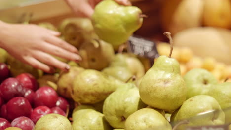 Manos-De-Mujer-Poniendo-Peras-En-Una-Tienda-De-Comestibles