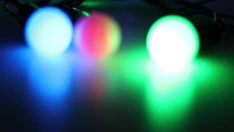 brillando tres linternas de varios colores en un fondo oscuro