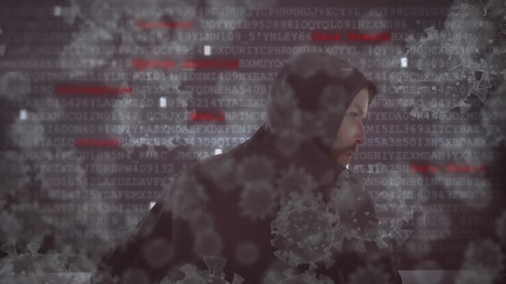 Animation af makro coronavirus Covid-19-celler, der spreder sig over en hættetrøjeklædt hacker med dataoptagelser