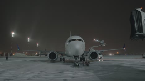 an airplane on an airport courtyard against dark sky