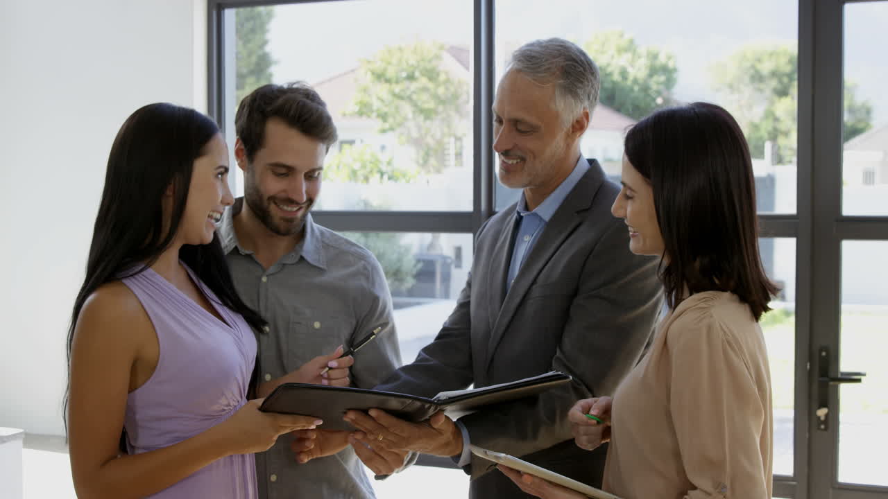 pareja firmando el acuerdo para conseguir su nueva casa