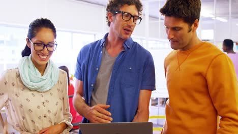 grupo de ejecutivos de negocios discutiendo sobre una computadora portátil