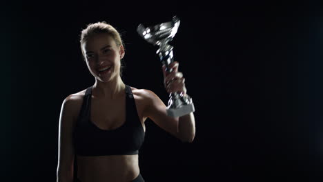 Sport-woman-winner-kissing-champion-trophy-in-slow-motion.-Woman-champion