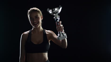 mujer ganadora del deporte besando el trofeo del campeón en cámara lenta. mujer campeona