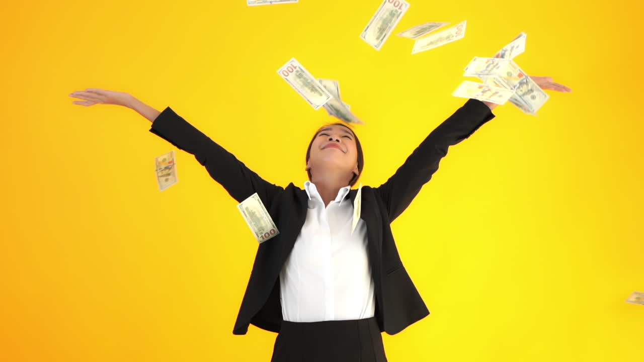 A young attractive businesswoman tosses paper money in the air then lets if fall on her and around her