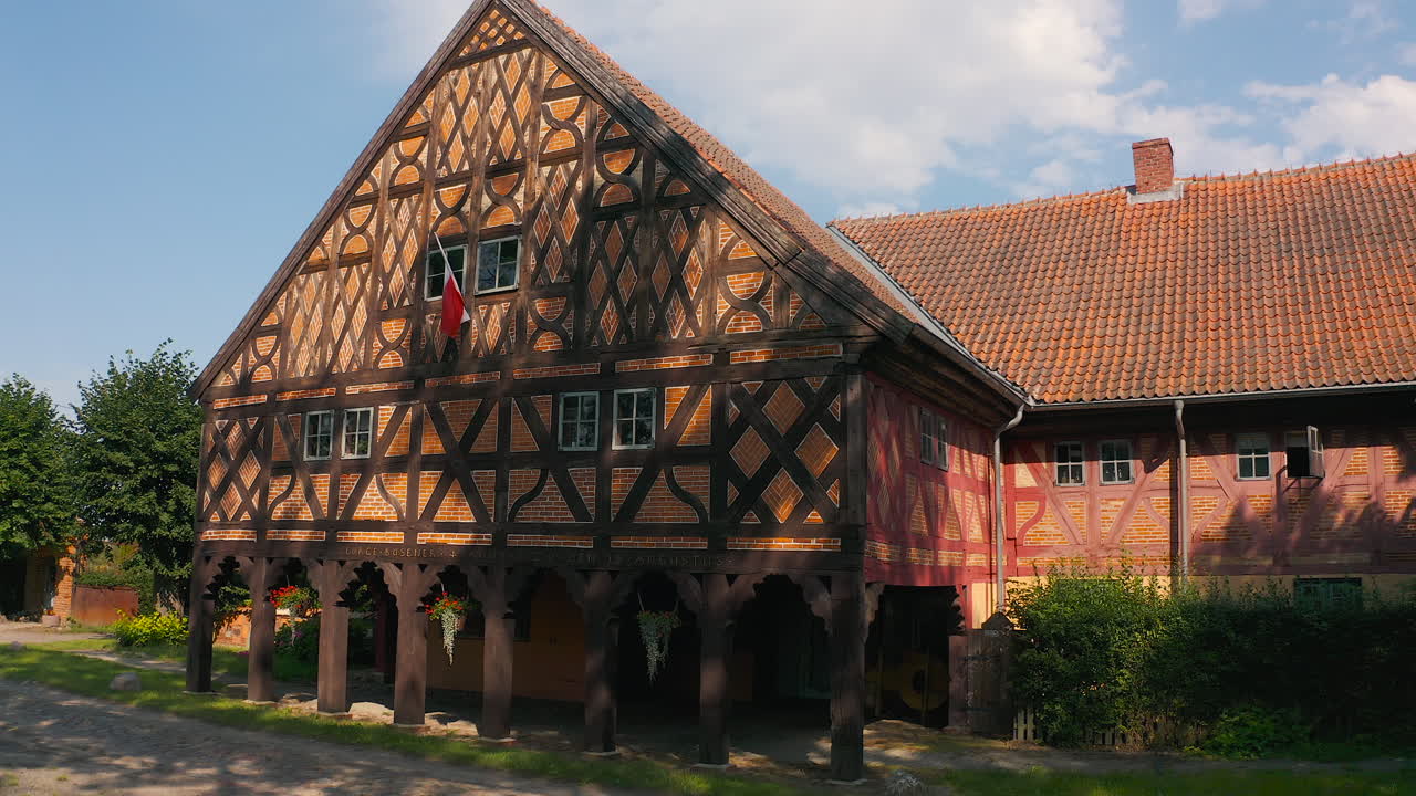 Aerial shot of Charming Mennonite arcade house in Poland's historic town, a glimpse of timeless architecture drone flying right