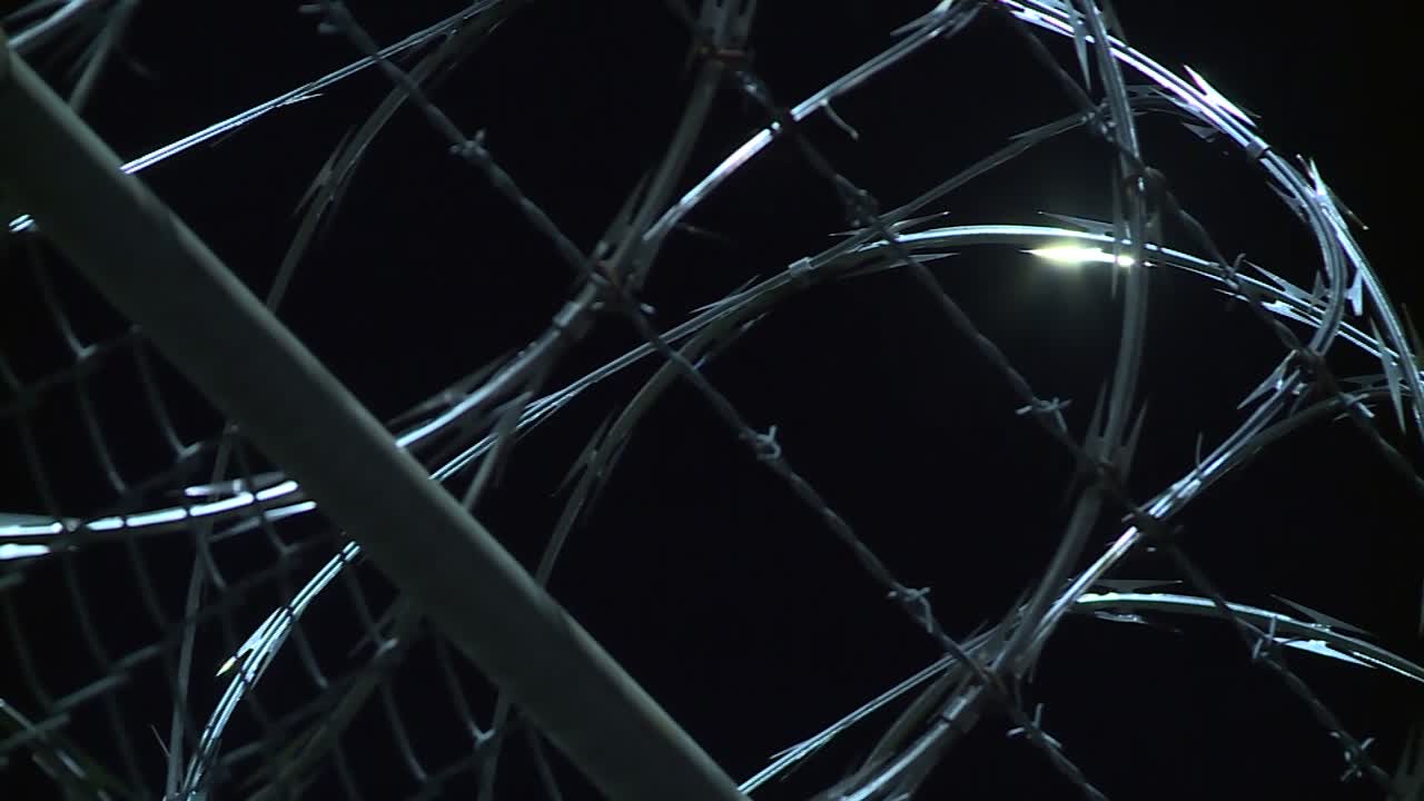 CLOSE UP BARB WIRE FENCE AT NIGHT