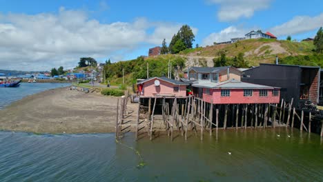 vuelo de drones coloridas casas tradicionales en pilotes en castro, chiloe 4k