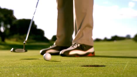 golfer putting the ball on the green