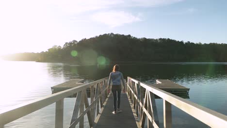 Mädchen-Geht-Eine-Brücke-Hinunter-Zu-Einem-Dock