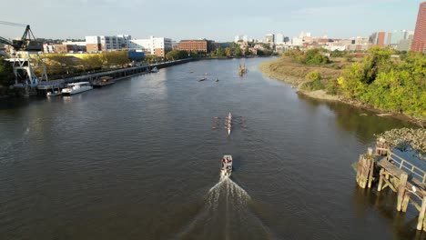 rowing team of rowers drone shot heading up river toward wilmington delaware