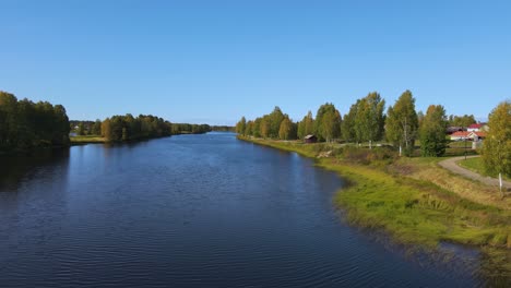 flying over the calm waters of vasterdal river near malung, dalarna, sweden