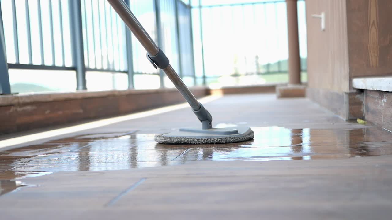 Mop cleaning wet floor on balcony