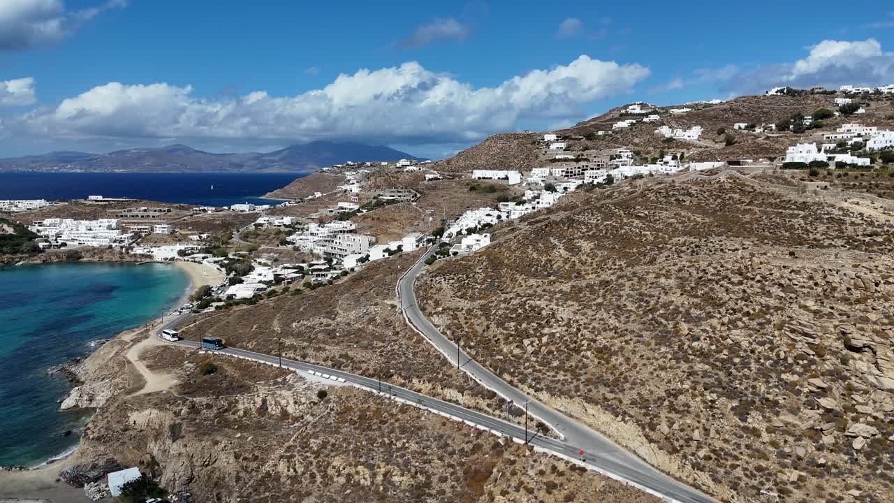 sun-drenched island of Mykonos, Greece, shoreline, homes, and hills aerial