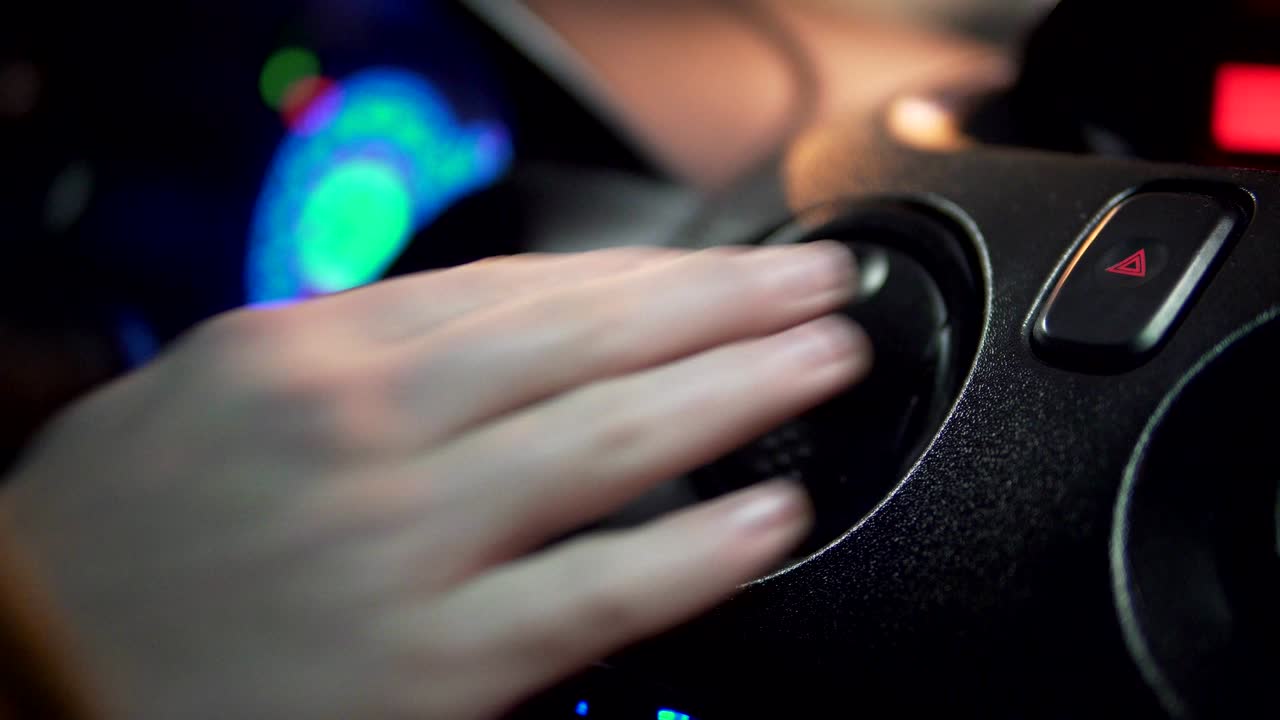 남자의 손이 차의 비상 조명 버튼을 때리고 있습니다.