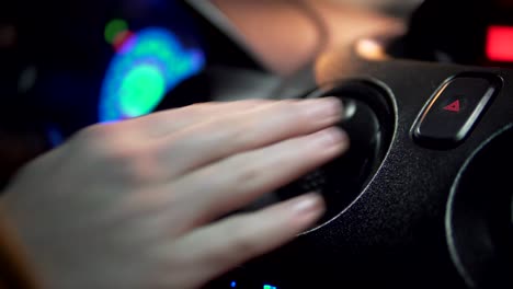 la mano del hombre golpeando el botón de la luz de emergencia del coche