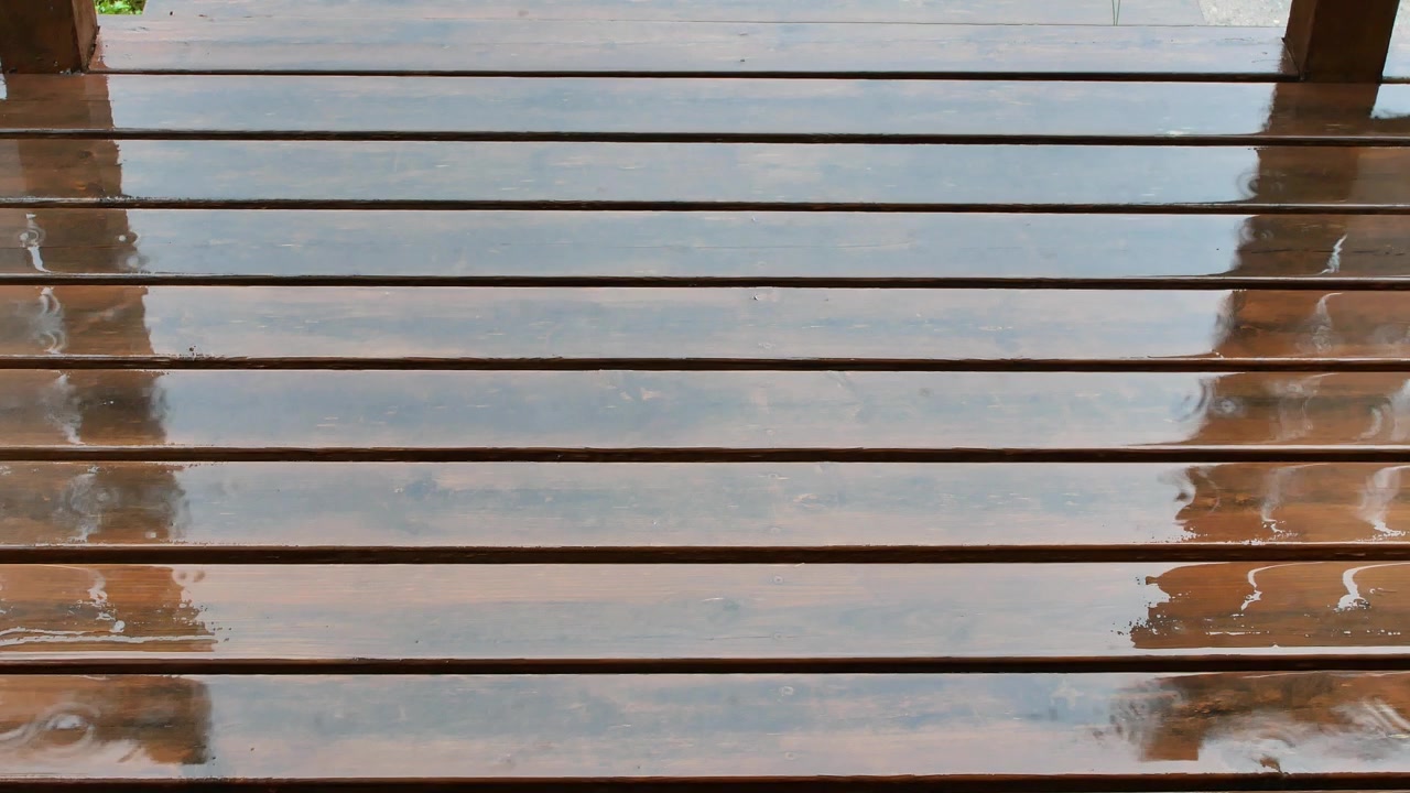 Raindrops Falling on Wooden Patio Decking on a Rainy Summer Day