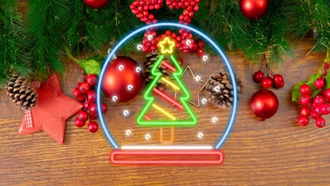 Animation-of-neon-chritmas-globe-with-tree-on-wooden-background-with-decorations