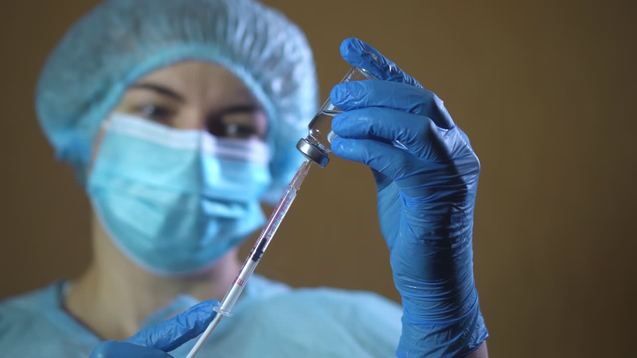 The nurse unfolds the syringe and needle. Close-up