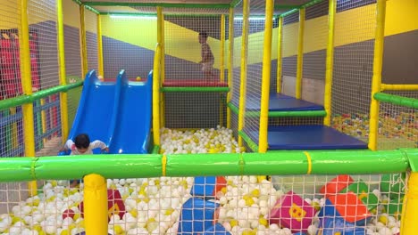 children are playing in the ball pit at the indoor playground. play with fun.