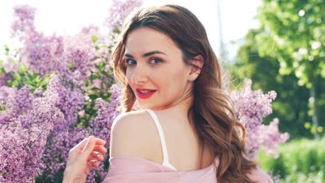 woman in a pink dress amongst lilac flowers