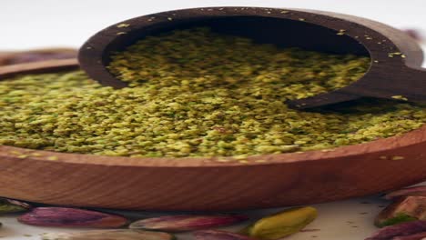 ground pistachios in wooden bowl and spoon