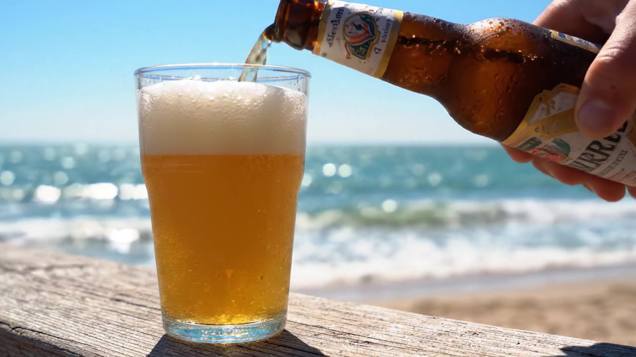 Bevanda rinfrescante gustata in spiaggia, che cattura l'essenza dell'estate con bollicine scintillanti e sole in una giornata limpida in riva all'oceano.