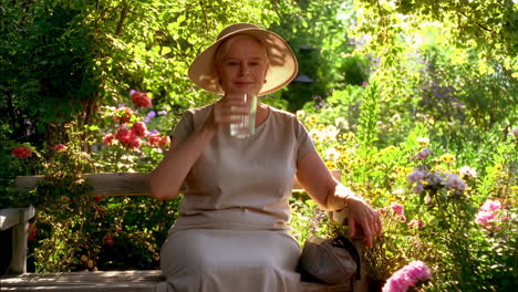 elderly woman enjoying a drink in a sunny garden
