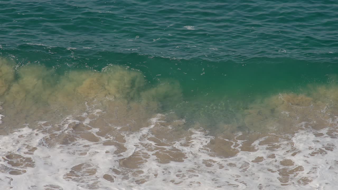 해가 뜨면서 이크스타파 지후아타네조 해변에 부히는 파도의 느린 촬영