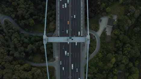 Coches-En-El-Puente-Rodeados-De-árboles,-Increíble-Vista-Aérea-De-Pájaros-Hacia-Adelante