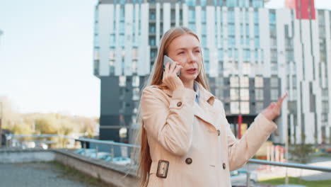 Mature caucasian businesswoman having remote conversation on smartphone on downtown city street