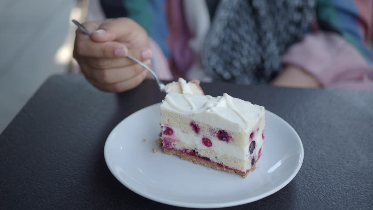 mujer comiendo un pedazo de pastel al aire libre