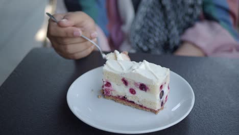 woman eating a piece of cake outdoors