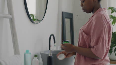 mujer aplicando cuidado de la piel en el baño